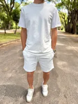 Conjunto deportivo blanco compuesto por una remera de manga corta de corte holgado y un short con cordón ajustable en la cintura.