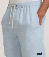 Bermuda de sarga con estampa rayada en color gris, de corte recto y largo por encima de la rodilla. Posee cintura elástica ajustable mediante cordón blanco y bolsillos laterales.