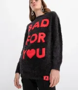 Buzo de tejido peluche negro con cuello redondo y manga larga. Presenta un estampado frontal en rojo que dice "BAD FOR YOU", donde la palabra "YOU" está reemplazada por un corazón.