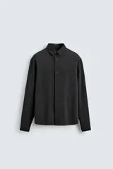 Camisa de corte relajado, color azul marino, con cuello solapa, manga larga con puños abotonados y cierre frontal de botones.