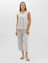 Pijama compuesto por remera sin mangas con escote redondo, botones frontales y detalle de puntilla, y pantalón tipo capri con cintura elastizada. Presenta un estampado floreado en tonos grises y rosados.