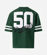 Remera de corte boxy y estilo deportivo, color verde oscuro, con diseño inspirado en el fútbol americano de Peanuts. Presenta cuello redondo, mangas cortas con franjas blancas horizontales y estampas localizadas de Snoopy en el frente.