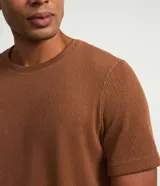 Remera de media malla verde militar con cuello redondo y mangas cortas, de corte clásico.