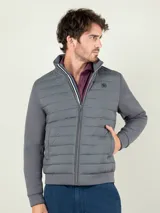 Campera gris marengo con frente acolchado tipo puffer y mangas y espalda de neopreno. Cuenta con cuello alto, cierre frontal y bolsillos laterales.