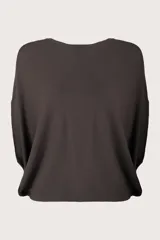 Poncho de tejido de punto en color café oscuro, con diseño fluido y corte holgado.