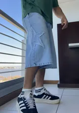 Bermuda de jean celeste, corte ancho y largo a la rodilla, con aplique de estrella en el lateral.