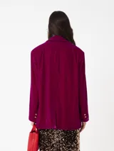 Blazer de terciopelo rojo, corte cuadrado y moderno, con botones dorados y forro interior.