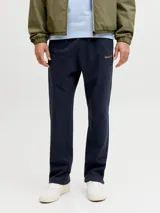 Pantalón jogging azul marino de fit relajado, tiro medio y cintura elástica. Confeccionado en tejido de felpa sin frisa, cuenta con elástico en la cintura, cordón ajustable y bordado sutil en el lateral.