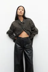 Pantalón ancho marrón de símil cuero, tiro alto y bolsillos frontales.