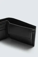 Billetera de hombre color negro con textura granulada, diseño clásico plegable con compartimento para billetes, ranuras para tarjetas y monedero con cierre de clip.