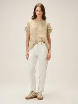 Blusa de lino color rosado, de corte recto y holgado, con cuello redondo y mangas cortas adornadas con volados.