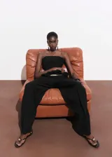 Pantalón de tiro medio color negro, con diseño recto y largo, trabillas en la cintura y dos bolsillos laterales. Cuenta con cierre oculto de botón, gancho y cremallera.