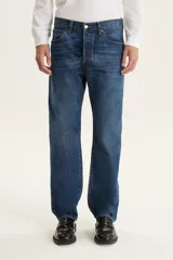 Pantalón de jean azul de corte recto, tiro medio y cierre con botones.