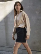 Camisa de seda color beige, de corte amplio y mangas largas con puños. Cierre frontal con botones.