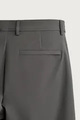 Pantalón regular fit de hombre color negro, confeccionado en tejido técnico ligero con cintura elástica, bolsillos frontales, bolsillos traseros de vivo y cierre frontal con cremallera y botón.