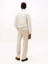 Buzo color crema de Tommy Hilfiger, de corte clásico y cuello redondo. Tiene el logo de la marca bordado en el pecho.