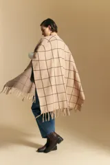 Poncho abierto de tejido de punto con diseño de cuadros grandes en contraste. Presenta un patrón reversible en tonos negro y marrón, con un estilo envolvente y versátil.