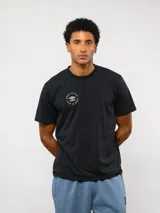 Remera negra de manga corta con cuello redondo. Presenta un estampado circular pequeño en el pecho con el logo de la marca Umbro y la frase Born to Play.