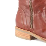 Bota de cuero marrón de caña media, con cierre lateral y taco bajo.