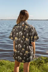 Camisa de corte oversize con estampado de palmeras, cuello clásico, manga corta y cierre frontal con botones de madera.