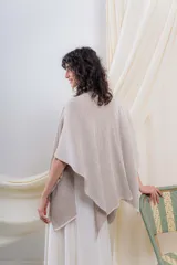 Ruana tejida en punto acanalado, con diseño bicolor en tonos crudo y beige, de caída fluida y envolvente.