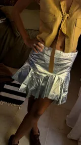 Minifalda de cuero color marrón oscuro, con fajón en la cintura y volados en el ruedo.