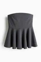 Top strapless de punto con escote recto y diseño ajustado en el torso que se abre en un peplum acampanado en la cintura.