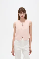 Musculosa cropped de viscosa color rosado, con cuello a la base, pequeña abertura frontal y detalle de hebilla metálica decorativa.