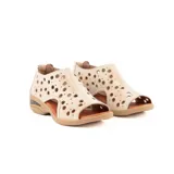 Sandalia baja de cuero color beige, con diseño cerrado en el talón y perforaciones circulares en el empeine. Cuenta con suela de goma con cámara de aire en el talón y plantilla marrón.