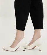 Zapato scarpin color blanco hueso, con puntera fina y taco fino diferenciado de 8 cm de altura. Fabricado en poliuretano.