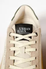 Zapatillas deportivas de cuero color crema, con detalles en gamuza color beige y verde.