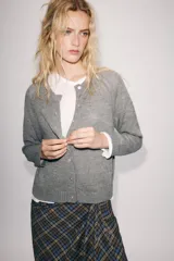 Chaqueta de punto gris con mezcla de lana, cuello redondo y manga larga. Cierre frontal con botones nacarados.