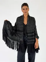 Pashmina de punto color beige con bordados sutiles y flecos largos en los bordes.
