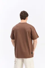 Remera de manga corta color beige con tejido texturado y pequeño logo impreso en el pecho.