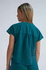 Blusa de lino color verde esmeralda, con cuello en V, cierre frontal con botones y mangas cortas tipo japonesa.