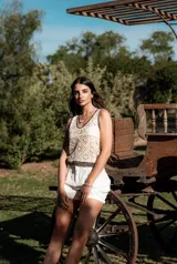 Blusa color beige con diseño calado y terminaciones en negro.