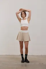 Top deportivo corto de sujeción media, con escote redondo y espalda abierta. Confeccionado en tejido elastizado de poliamida y spandex, con elástico interno en la cintura para mayor ajuste.