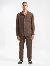 Chaqueta marrón de lino italiano, de corte relajado, con tres bolsillos frontales y cierre con botones.