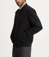 Chaqueta bomber azul marino lisa, con cierre frontal, cuello redondo y bolsillos laterales.