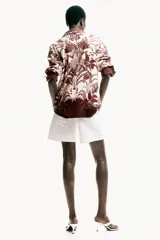 Camisa de viscosa con diseño estampado, corte oversized, cuello clásico, botones ocultos en la parte delantera y mangas largas.
