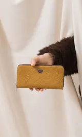 Billetera larga de cuerina color celeste con cierre perimetral, múltiples compartimentos internos para tarjetas, billetes y un monedero con cierre.