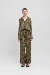 Camisa de pijama confeccionada en satén con estampado animal, ribetes en contraste y bolsillo de parche. Corte regular-entallado.