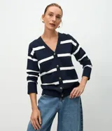 Cardigan de punto con diseño de rayas horizontales anchas en azul marino y blanco. Presenta escote en V, cierre frontal con botones, mangas largas con puños acanalados y dos bolsillos frontales aplicados.