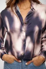 Camisa de manga larga con cuello camisero y estampado abstracto en tonos azul oscuro y rosado pálido.