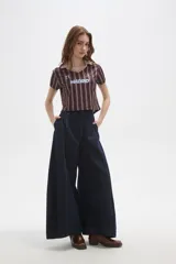 Pantalon de jean estilo barrel con tiro alto, bolsillos laterales y costuras reforzadas a la vista.