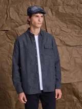 Overshirt de paño gris oscuro, con cierre frontal de botones, cuello clásico y un bolsillo frontal con solapa.