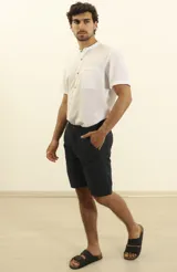 Bermuda de gabardina azul oscuro, corte recto, con bolsillos laterales y traseros.