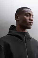 Campera canguro de Zara Athleticz, modelo relaxed fit, confeccionada en tejido técnico compacto elástico con mezcla de algodón en color azul marino. Cuenta con cuello subido con capucha, manga larga con bolsillo lateral con cierre, bolsillos frontales con cierre y acabado termofijado, cierre frontal de doble dirección y logo estampado en el bajo.
