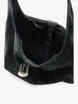 Cartera tipo hobo de diseño amplio y estructura flexible, confeccionada en gamuza color marrón con acabado desgastado. Cuenta con un asa única para llevar al hombro y un cierre frontal con detalle de hebilla metálica decorativa.