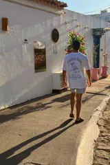Remera blanca de corte amplio con estampa en la espalda que incluye texto y dibujo de una reposera.